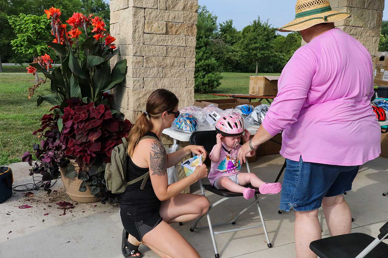 A toddler getting fitted for a helmet and the bike ride
