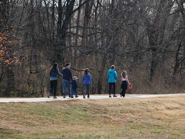 A group of adults and children walking on the trail