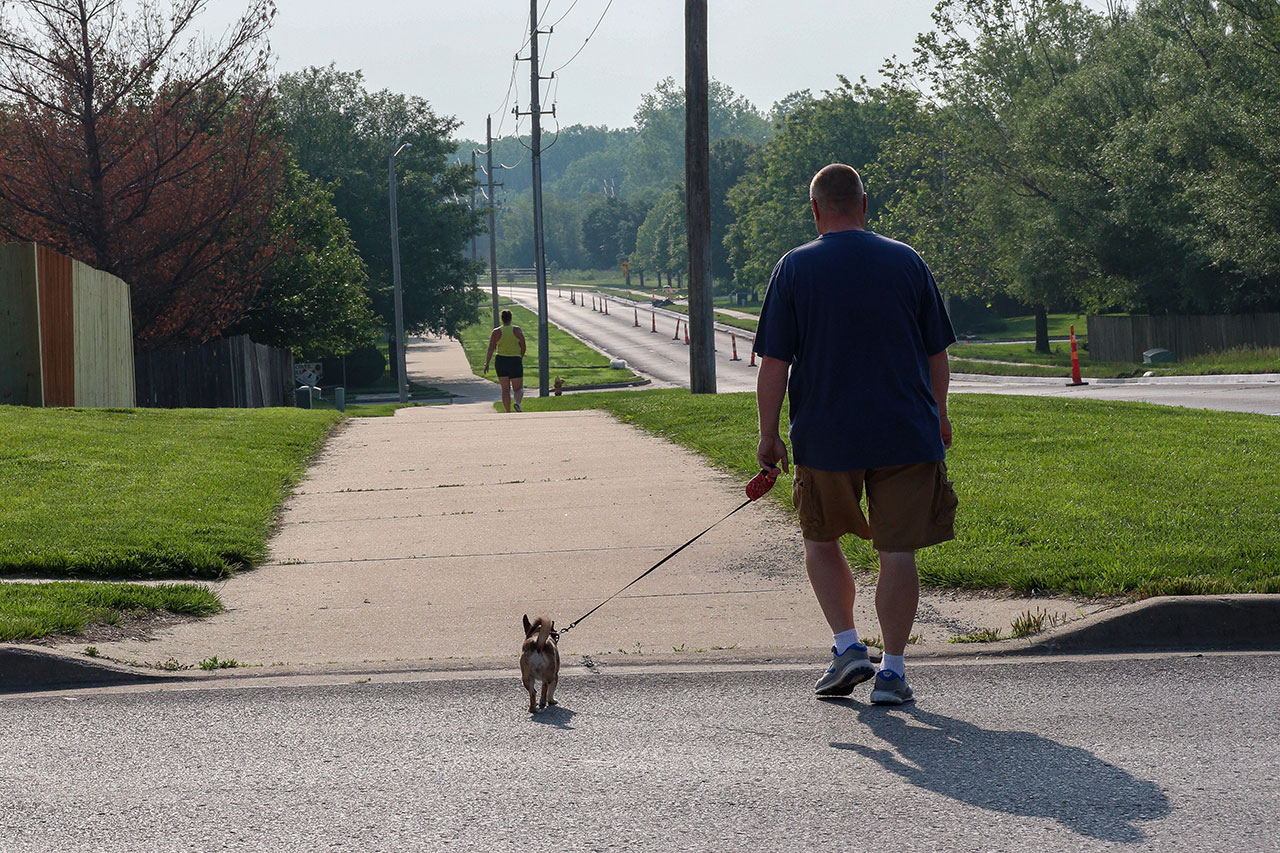 A man walking his dog on the Loop on 27th Street