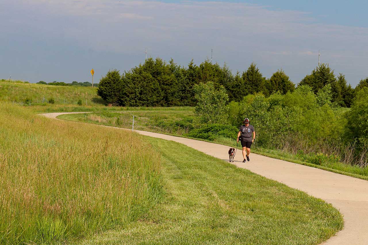 A woman walking her dog on the trail