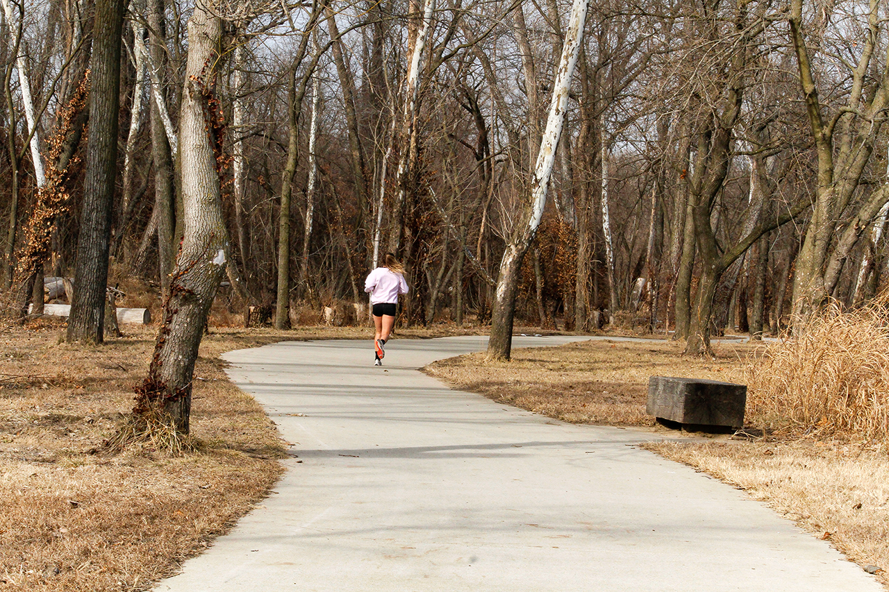 A woman running on the trail in Burcham Park