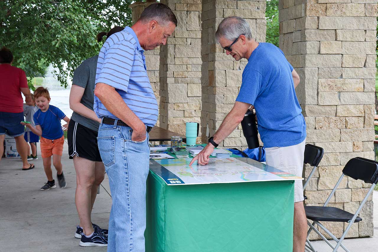 A person getting local area trail information at the FLAT table