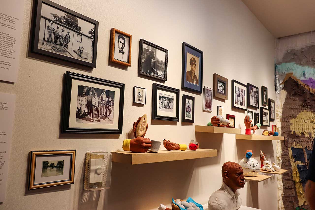 A wall of photos of La Yarda residents and ceramic pieces made from molds of La Yarda descendants