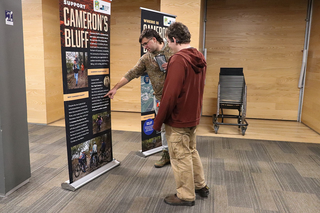people looking at the banners at the cameron's bluff open house