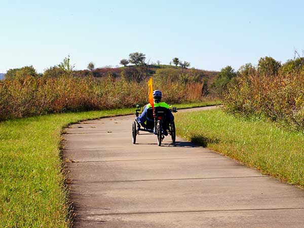 A person riding a recumbent bike on the Sanders Mound Trail